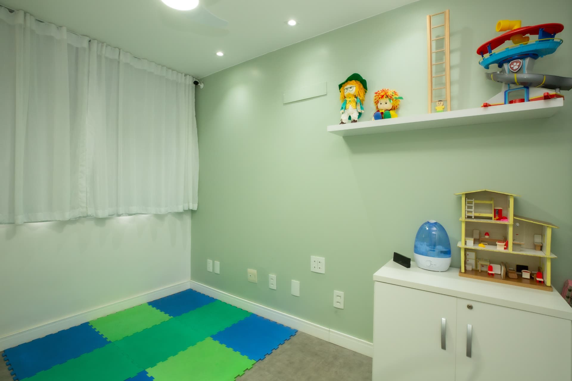 Sala lúdica com tapete colorido e brinquedos