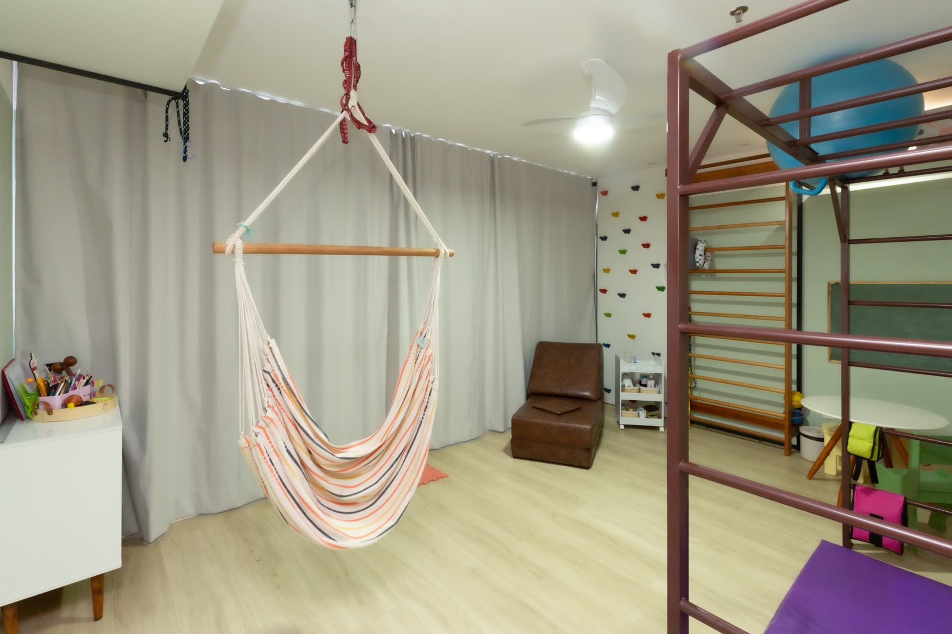 Sala de fisioterapia com rede e parede de escalada