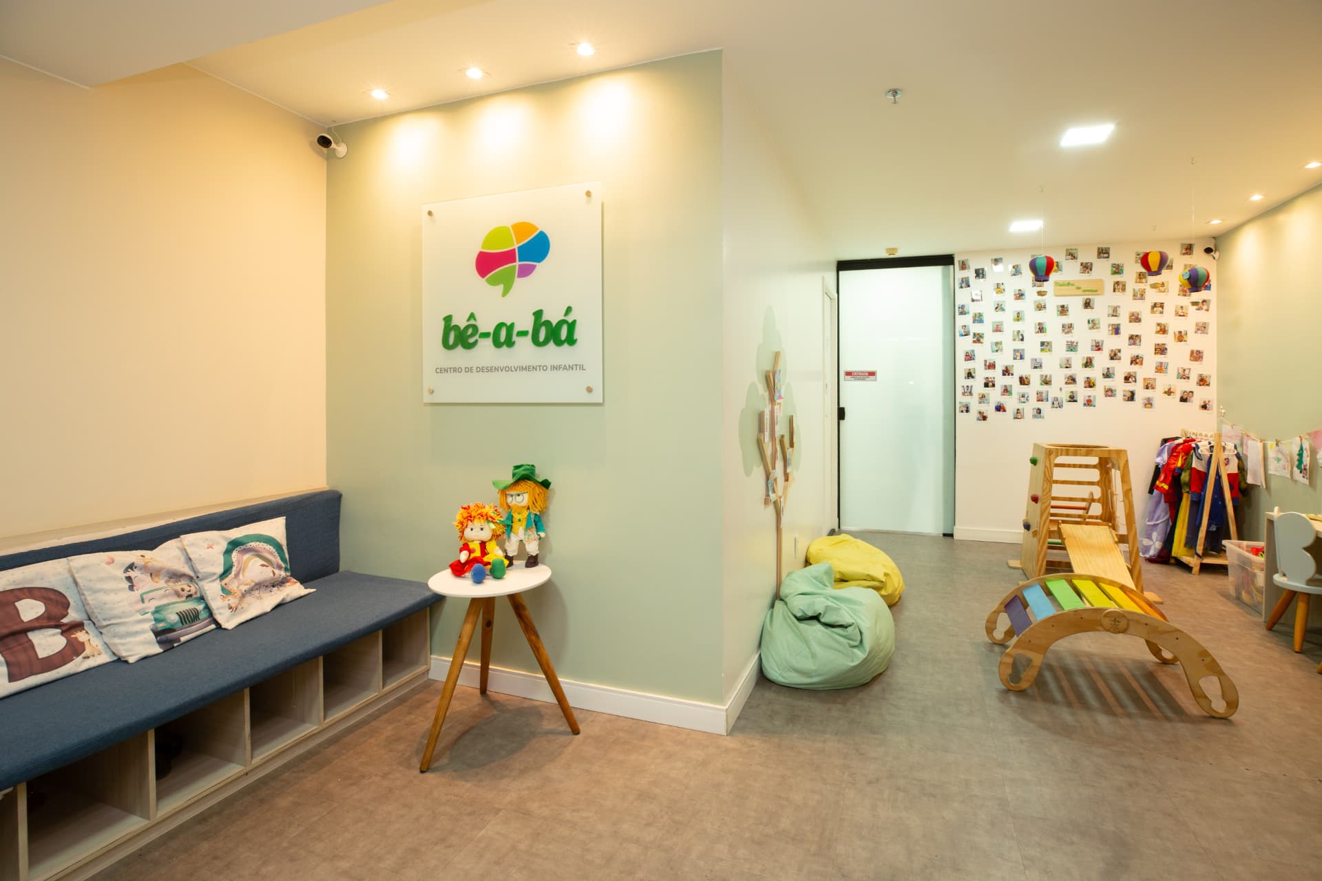 Sala de espera com painel da logo bê-a-bá