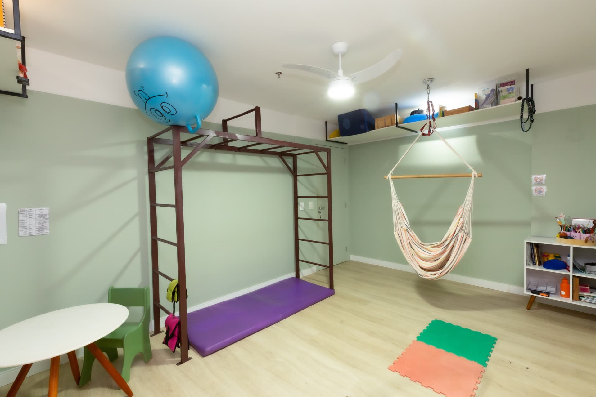 Sala de terapia com balanço, escada e colchonetes