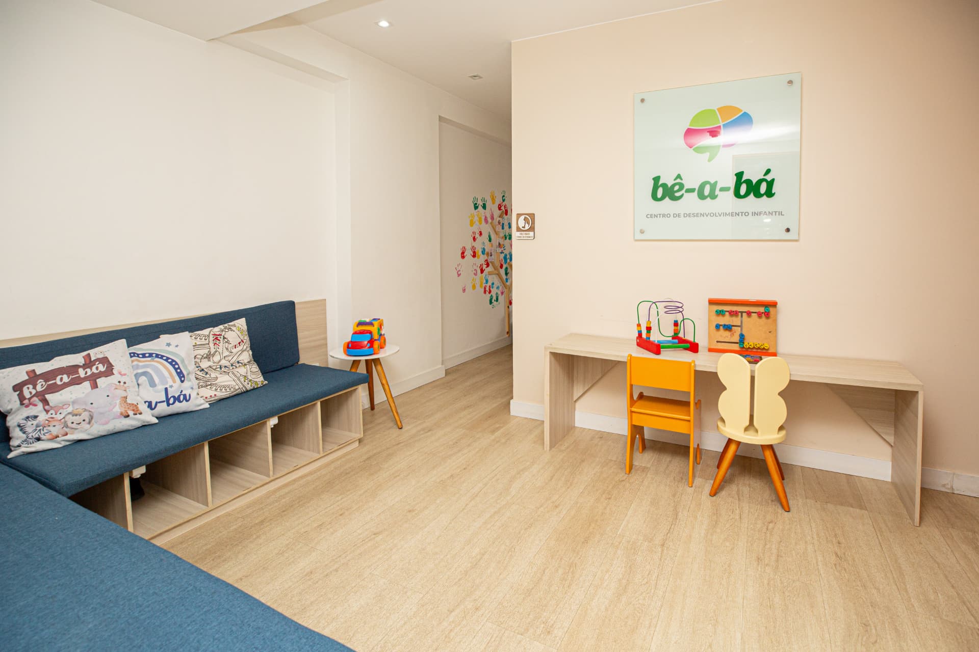 Recepção da bê-a-bá com sofá e mesa de atividades